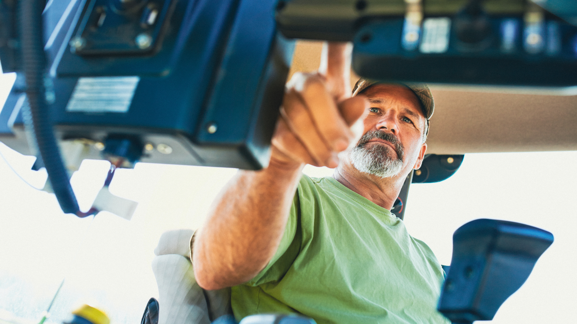 Farmer working inside the cab of a modern tractor